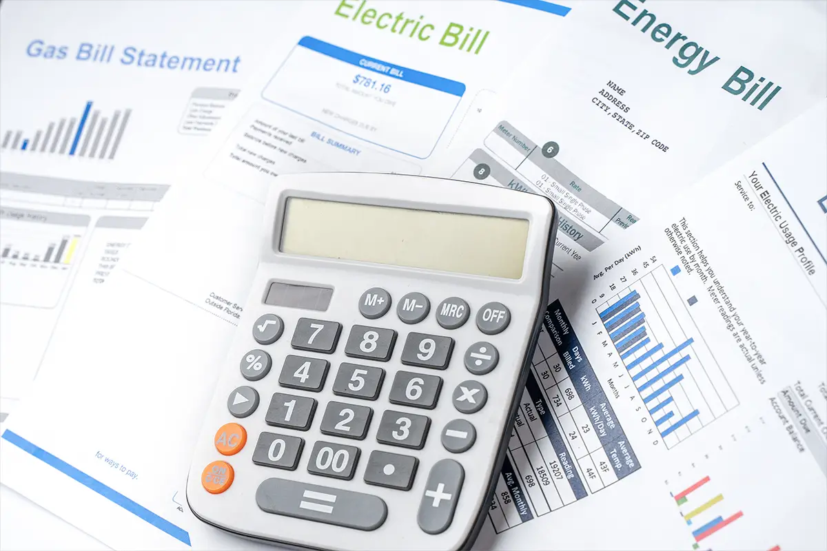 Photo of calculator on top of pile of monthly bills