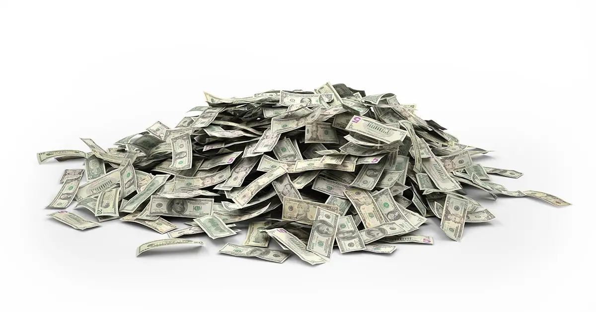 Photo of different U.S. bills forming a cash pile with white background. Photo by Adobe Stock.