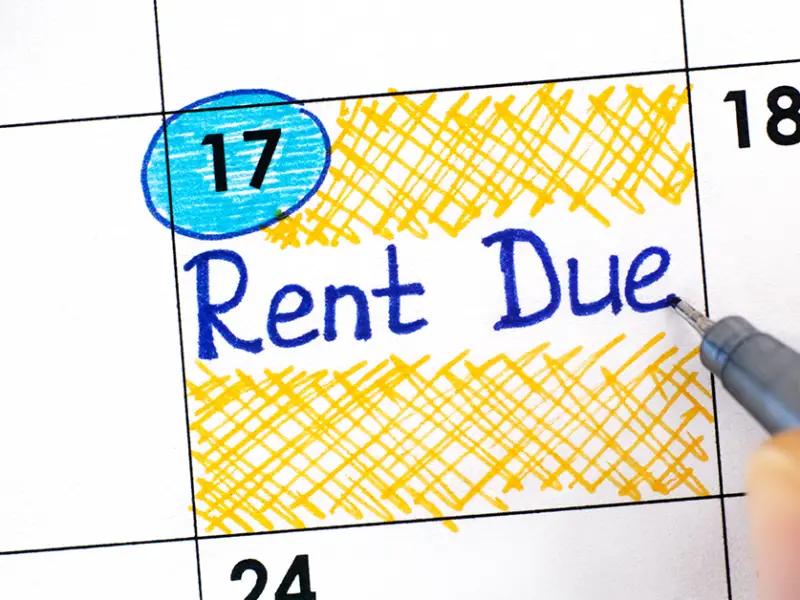 Photo closeup of a person writing "Rent Due" on their monthly calendar.