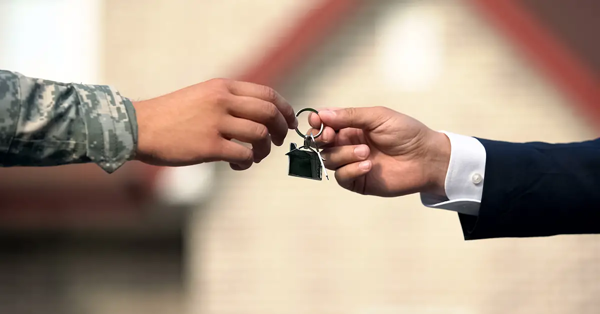 Photo of a verteran's hand reaching out to receive house keys from their landlord.