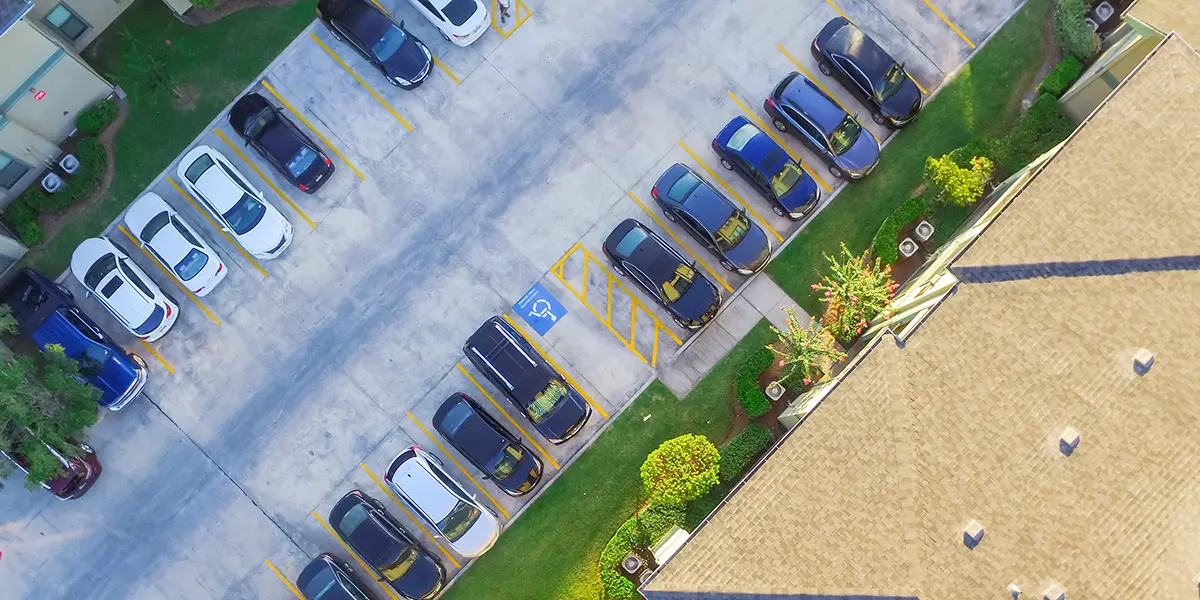 Aerial photo of a parking lot for an apartment complex with a handicapped parking space in the center.