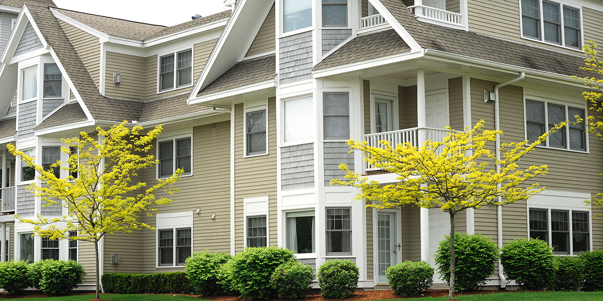 Photo of a modern apartment community with landscaping and porches.