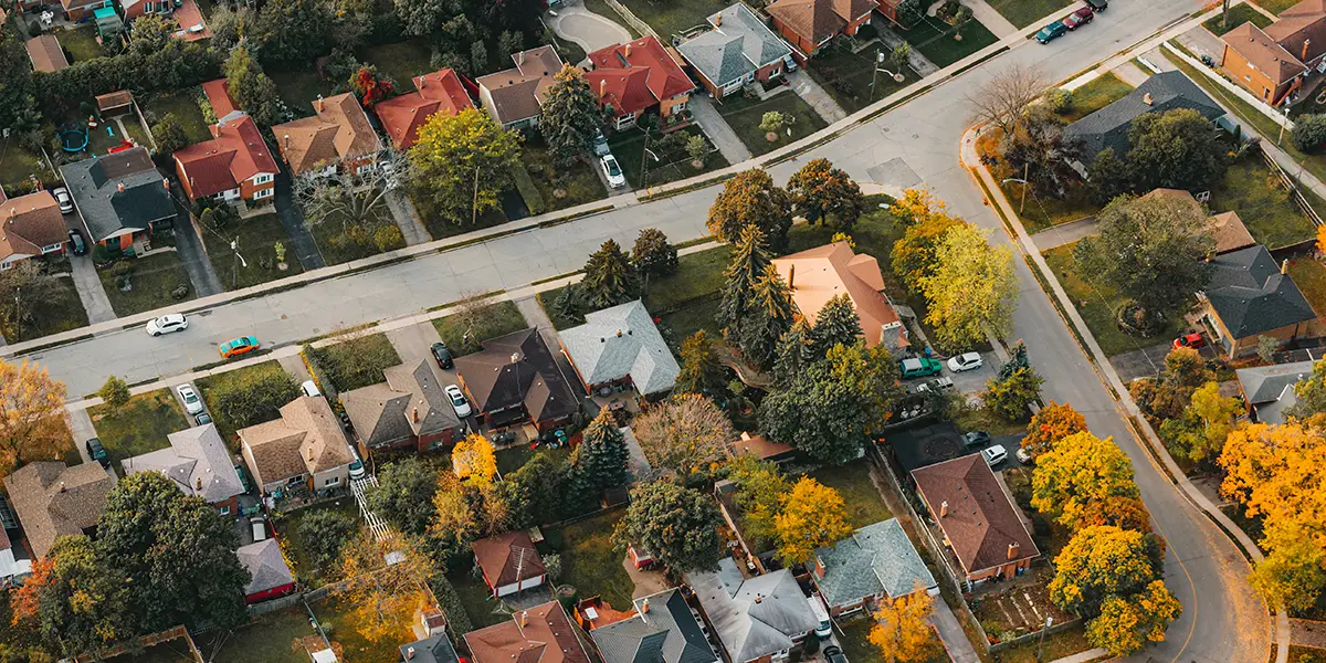 Overhead photo of a rural community with trees that are changing to yellow and red colors during the fall season.